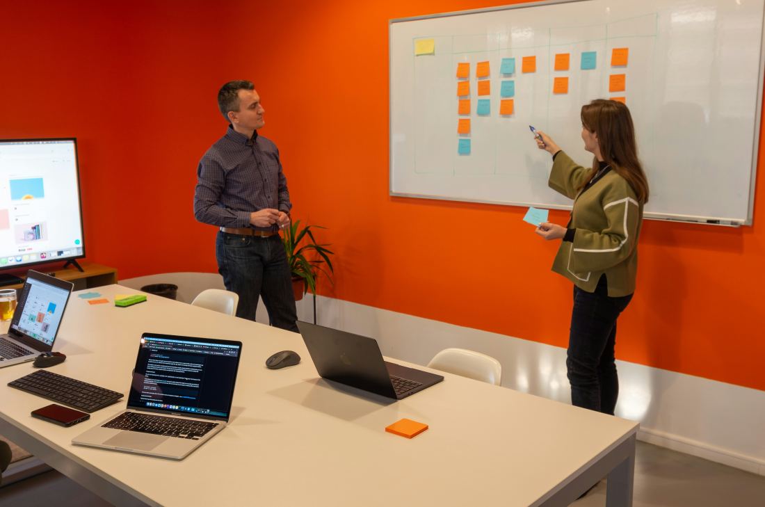 Product team arranging a kanban board of notes